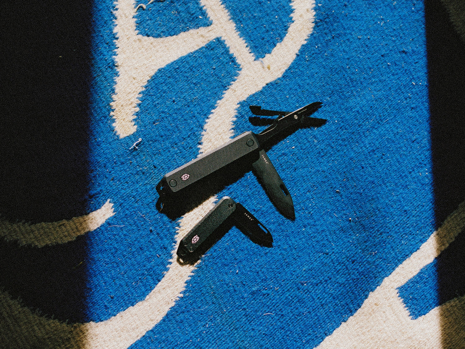 The Ellis multitool on a rug with the Elko pocket knife.