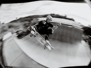 Professional skateboarder grabbing the tail of his board on a half pipe in San Diego, California.