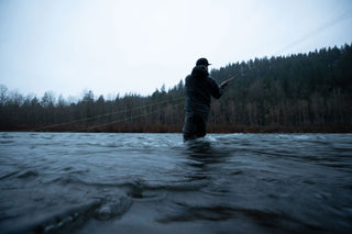 A man fly fishing in a river.