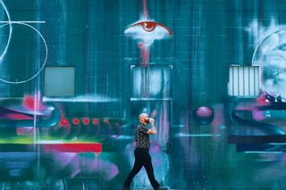 Death & Co bartender Jack Stevenson strolling in front of a mural.