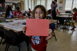 An art student of Kahuku elementary school showing a boat painting.