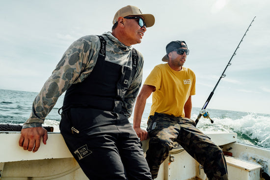 Two fishermen sitting on the transom of a fishing boat of the coast of Mexico.
