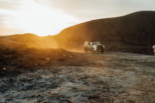 The sun setting over dusty dirt roads in Baja California.