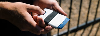 A person deploying their credit cards from the Lowe card case wallet.