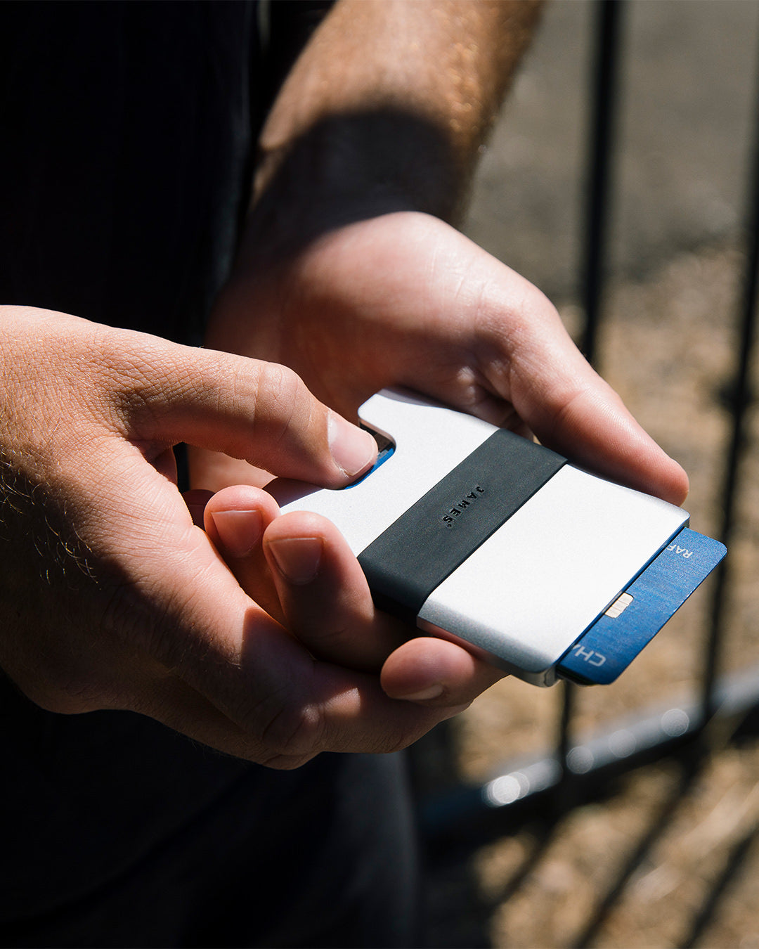 A person sliding a card out of the Lowe minimalist wallet.