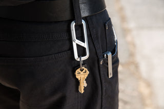 The Madison carabiner hanging from a belt loop.