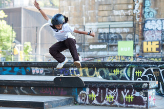 A skater kick flipping off a feature at a skatepark in New York.