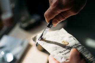 A man using the Ellis slip joint ultra slim pocket knife to open a bag of coffee.
