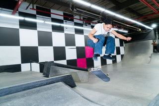A girl skater kick flipping her board over a feature.