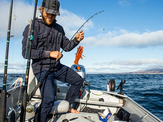 Professional surfer Connor Coffin with a small catch on his boat. 