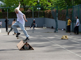 Artist and skateboarder Sebo Walker doing a crook grind on a rail.